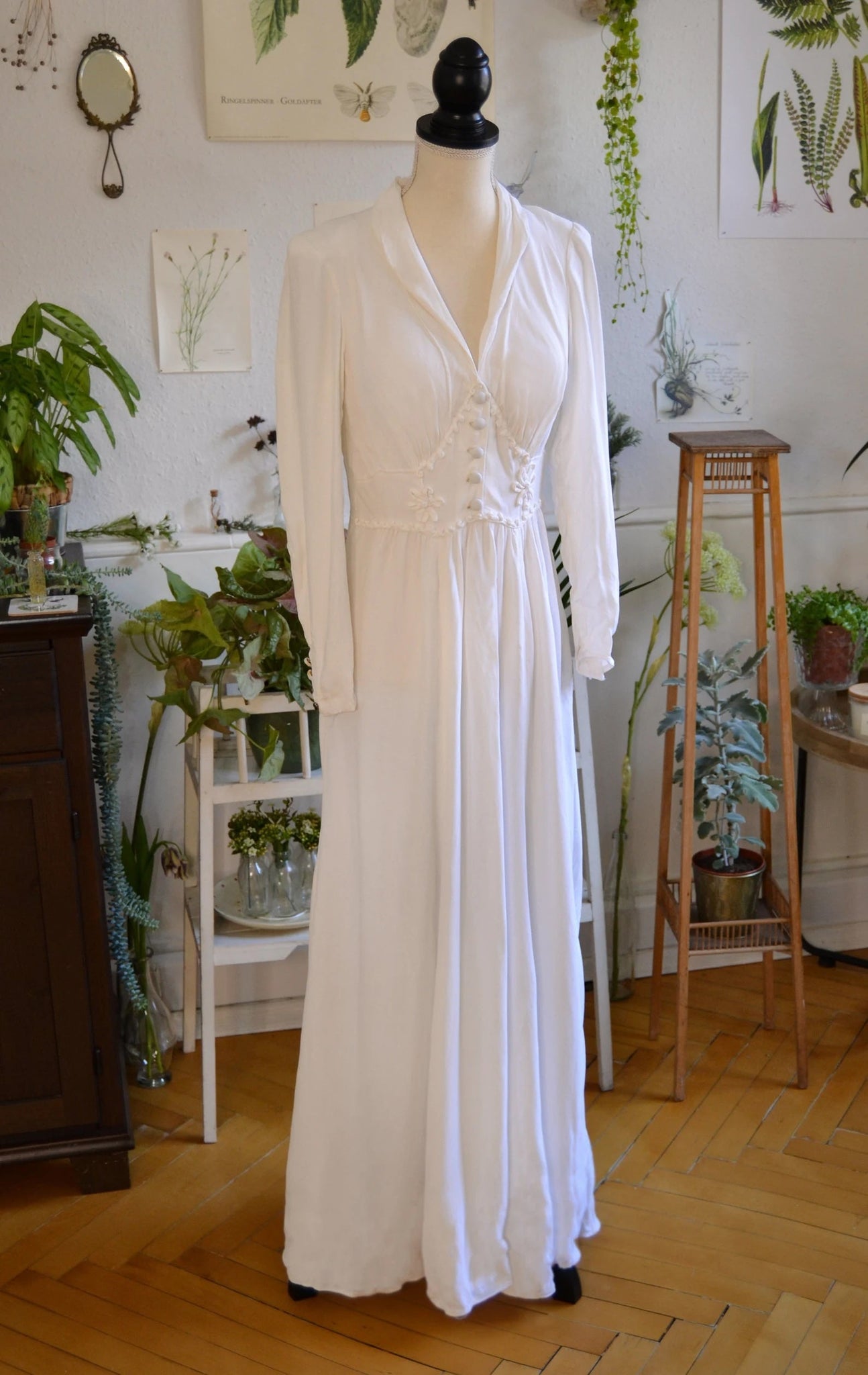Floor length long sleeve linen wedding dress with flower details on the bust